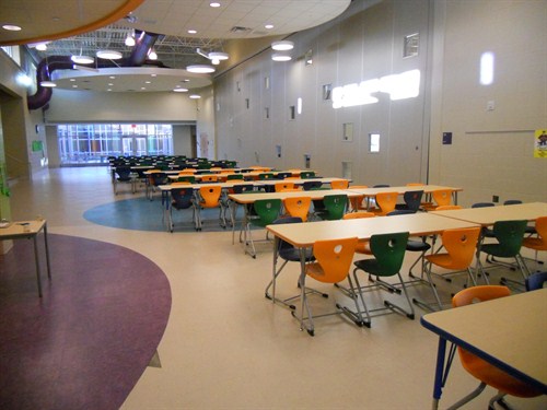 photo of cafeteria with tables and chairs ready to serve students.