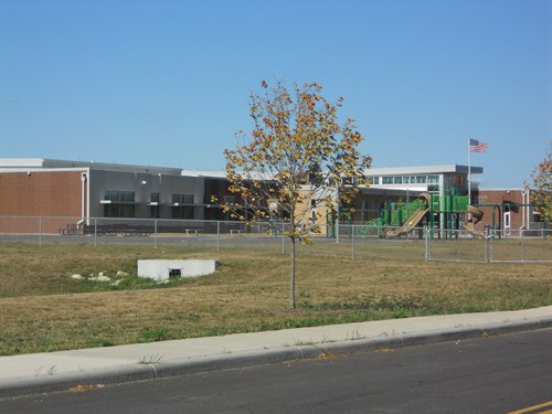 front outside view of school with large playground. 