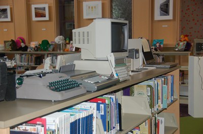 photo of many old typewriters and a desk top computer.