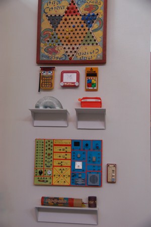 photo of close up view of vintage games and trinkets displayed on wall.