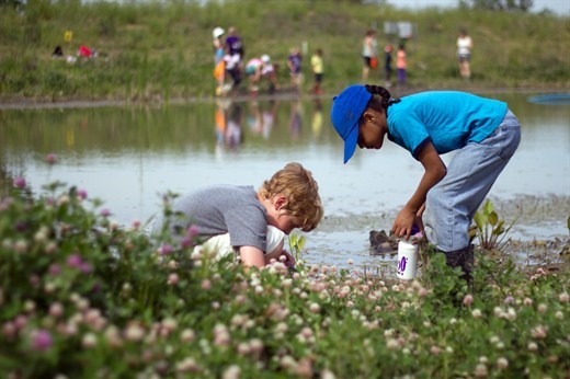 two students looking at ground investigating something they found