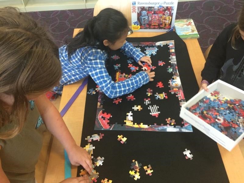 photo of students working on putting a puzzle together.