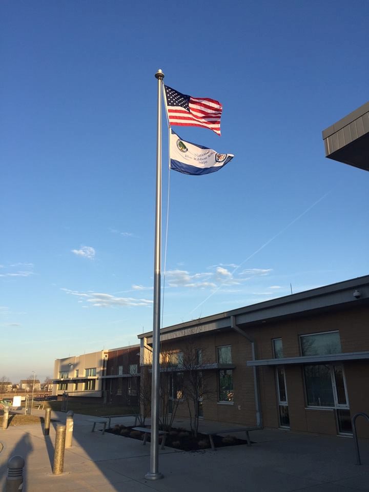 flag pole with american flag and 2016 national blue ribbon school flag waving from the pole. 