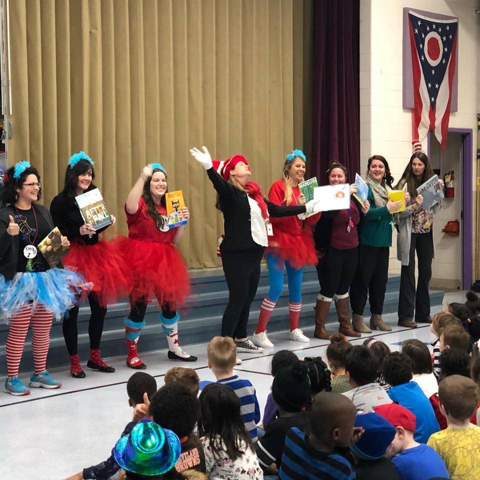 Staff dressed as Dr. Seuss characters at a school assembly