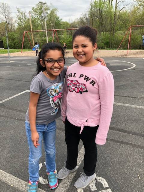 Two girls standing close and smiling