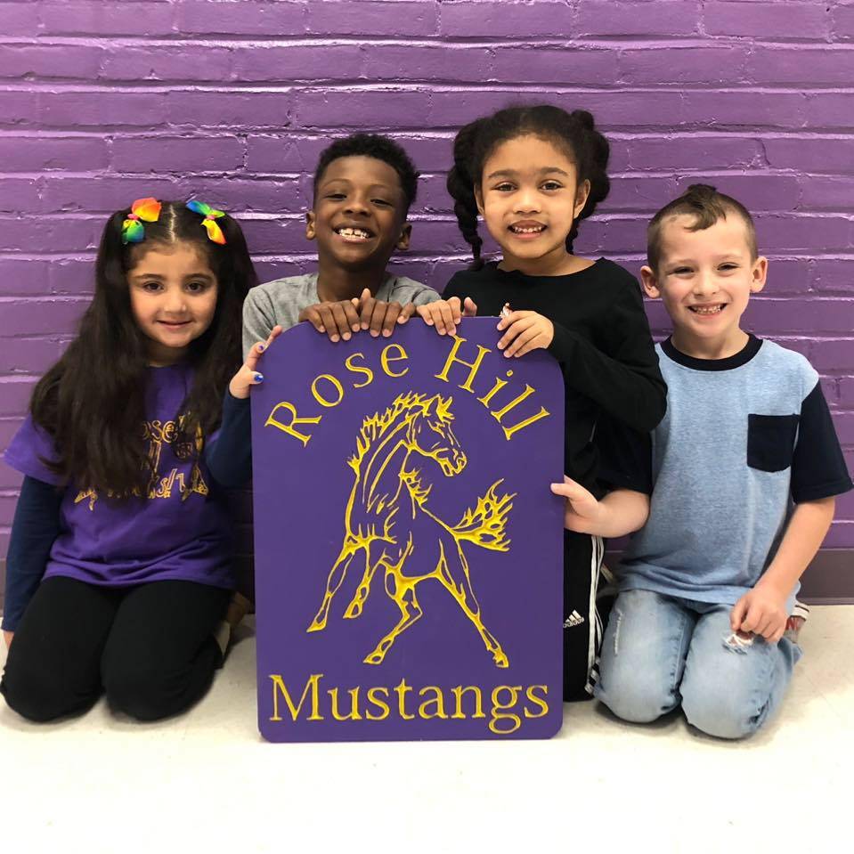 Rose Hill Students posing with a sign of their school name and mascot