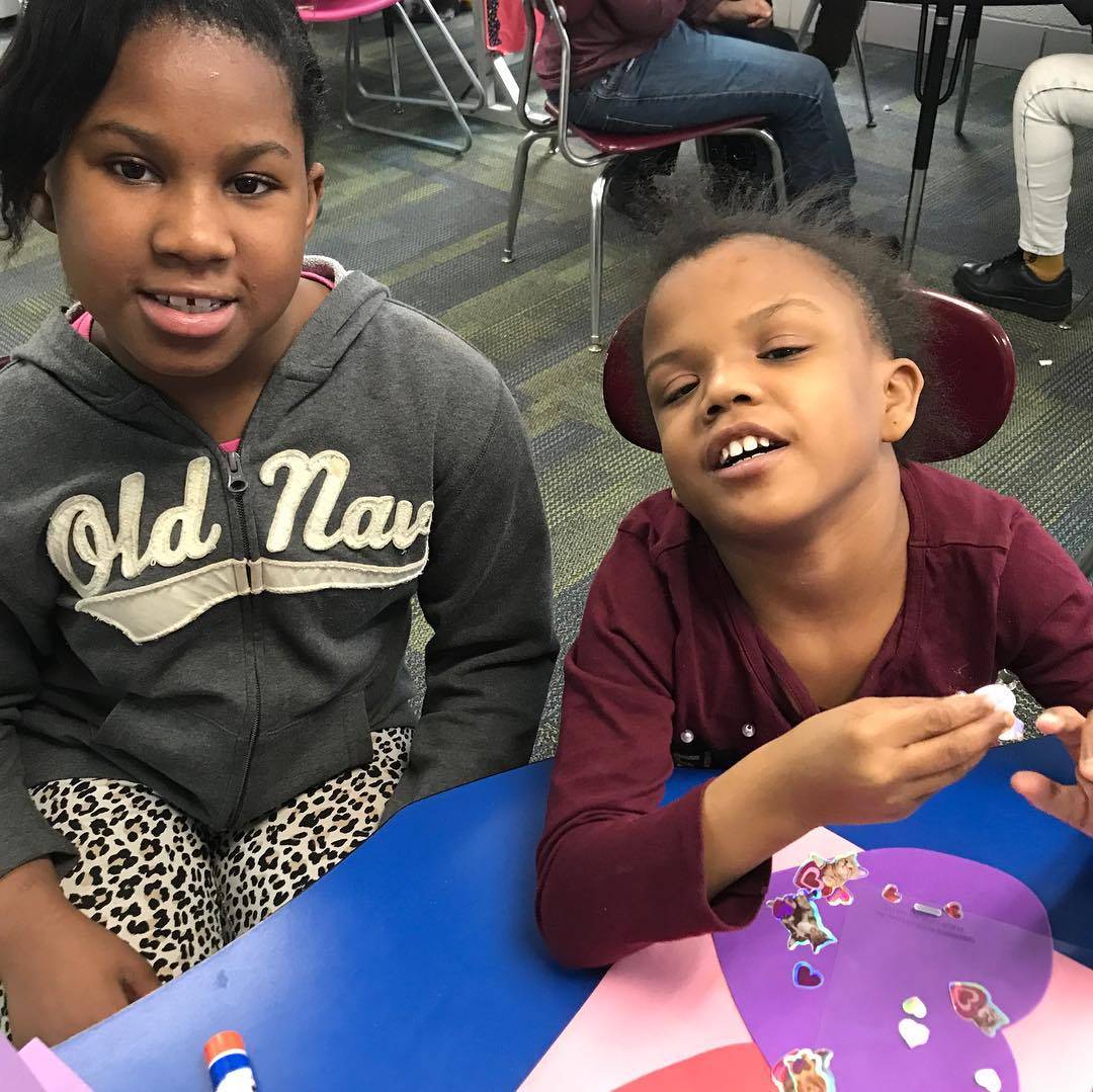 Two girls working on Valentine&#39;s projects