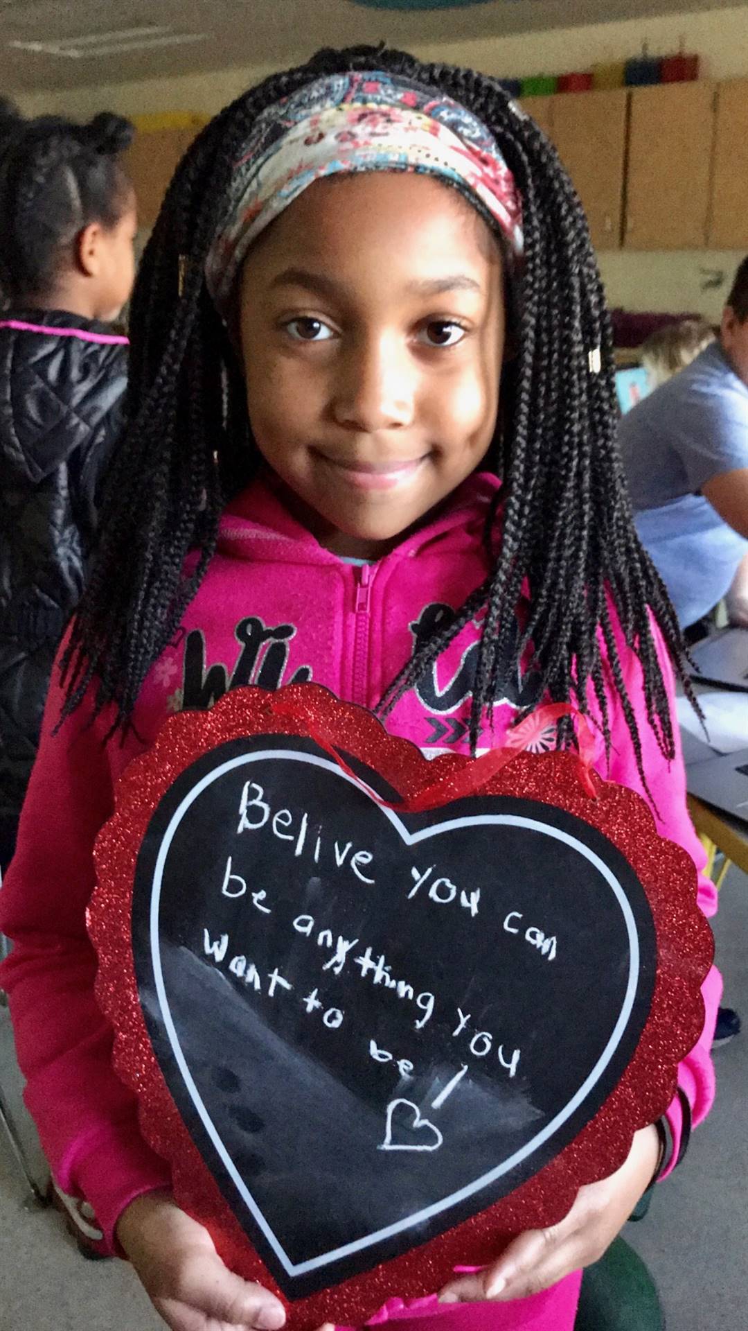 Rose Hill Student holding a large handmade valentine card