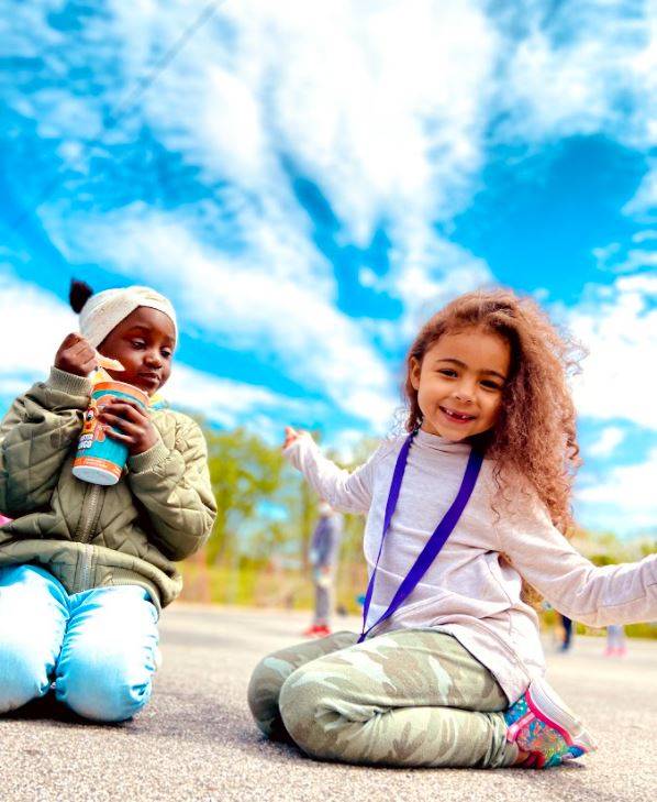 Two Rose Hill Students sitting outside under a bright blue sky
