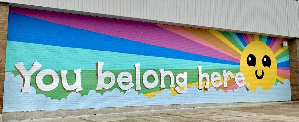 Wall mural of a sun that says "you belong here"