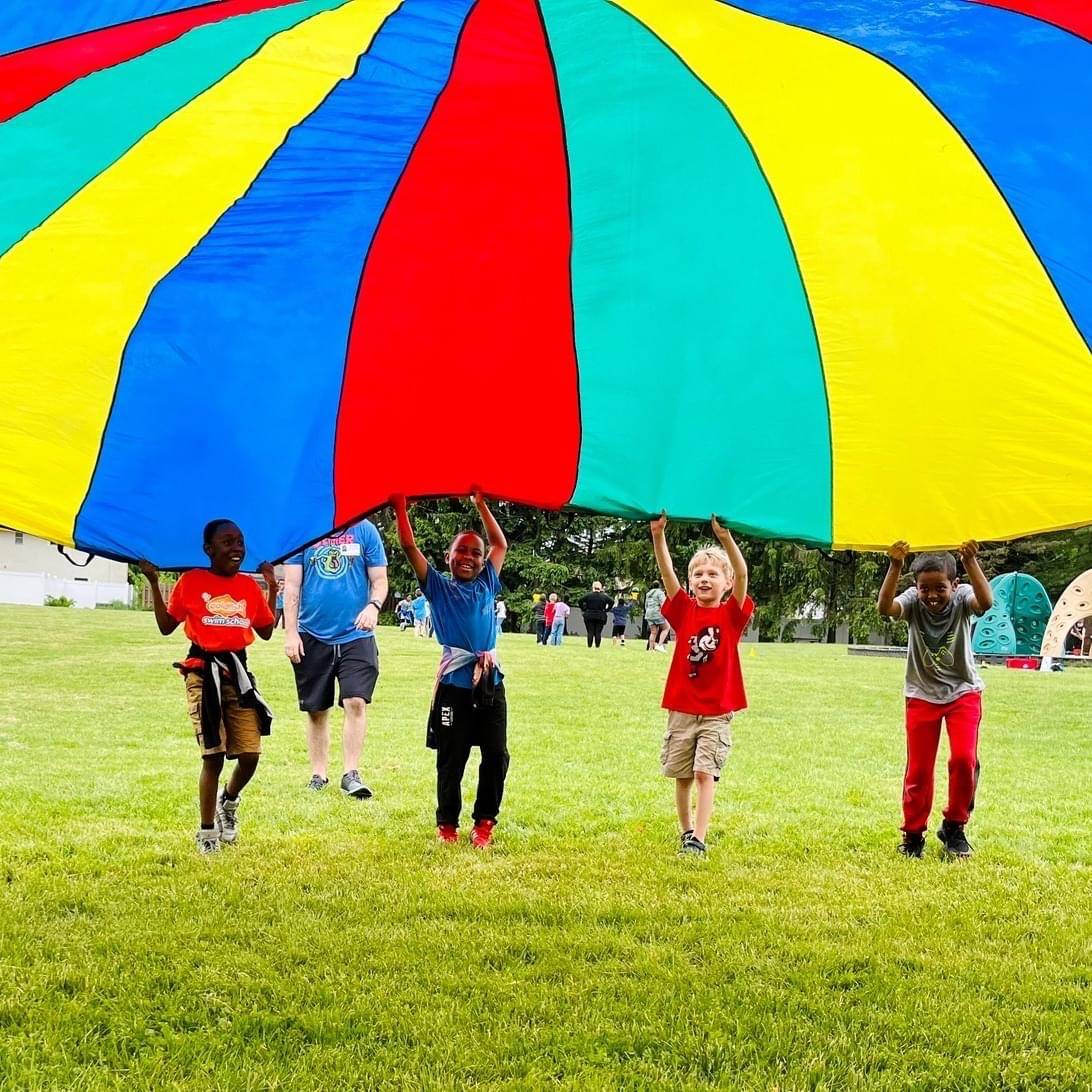 Kids playing with a parachute during field day