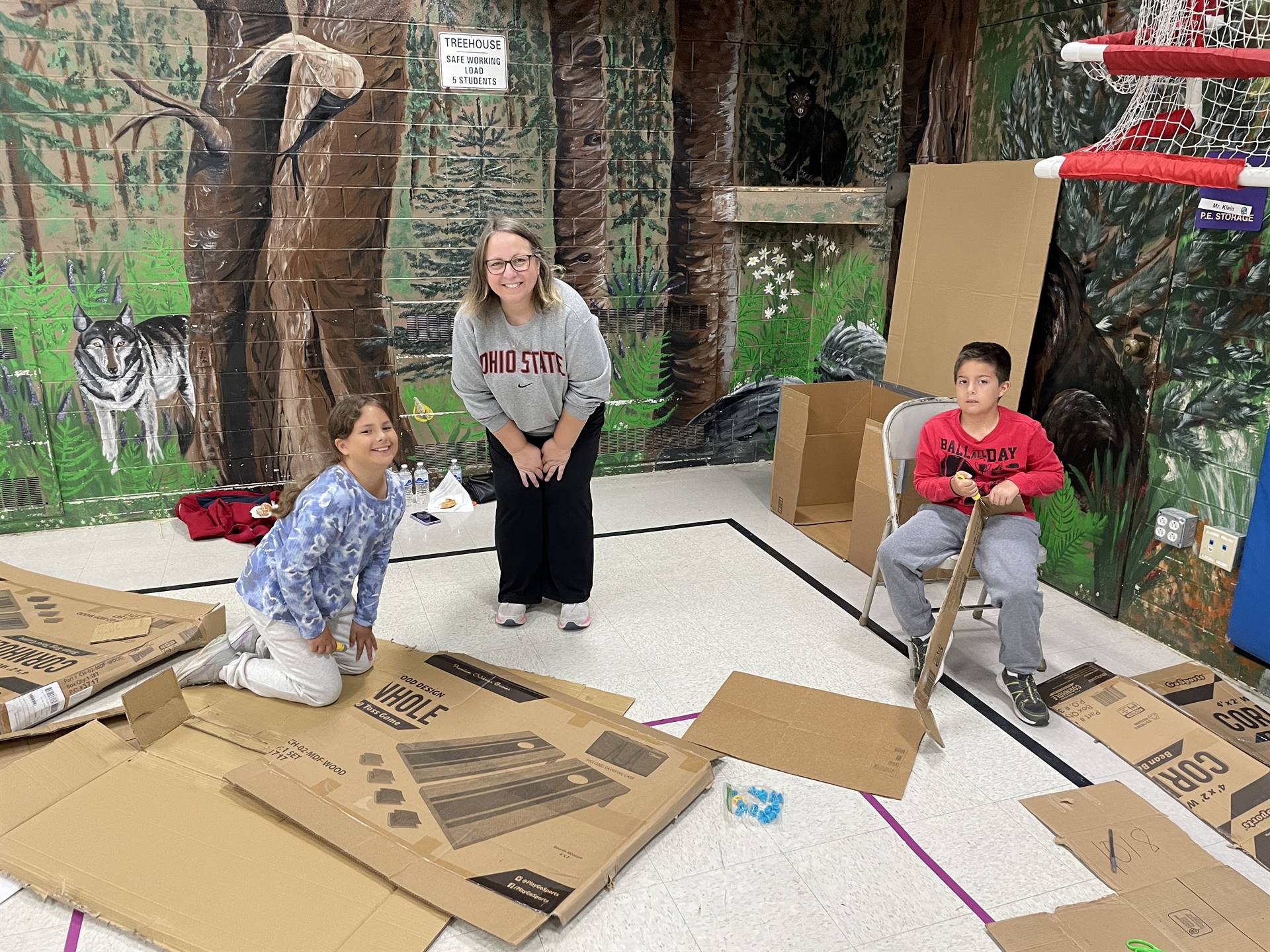 Firebird families in the gymnasium build with cardboard. 