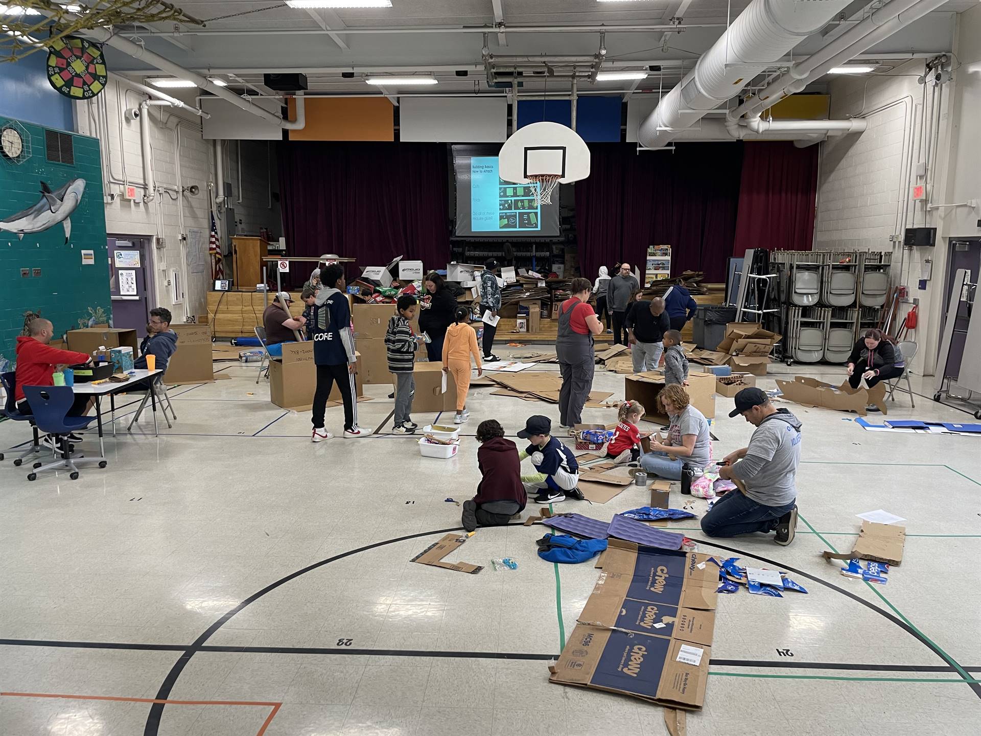 Firebird families in the gymnasium build with cardboard. 