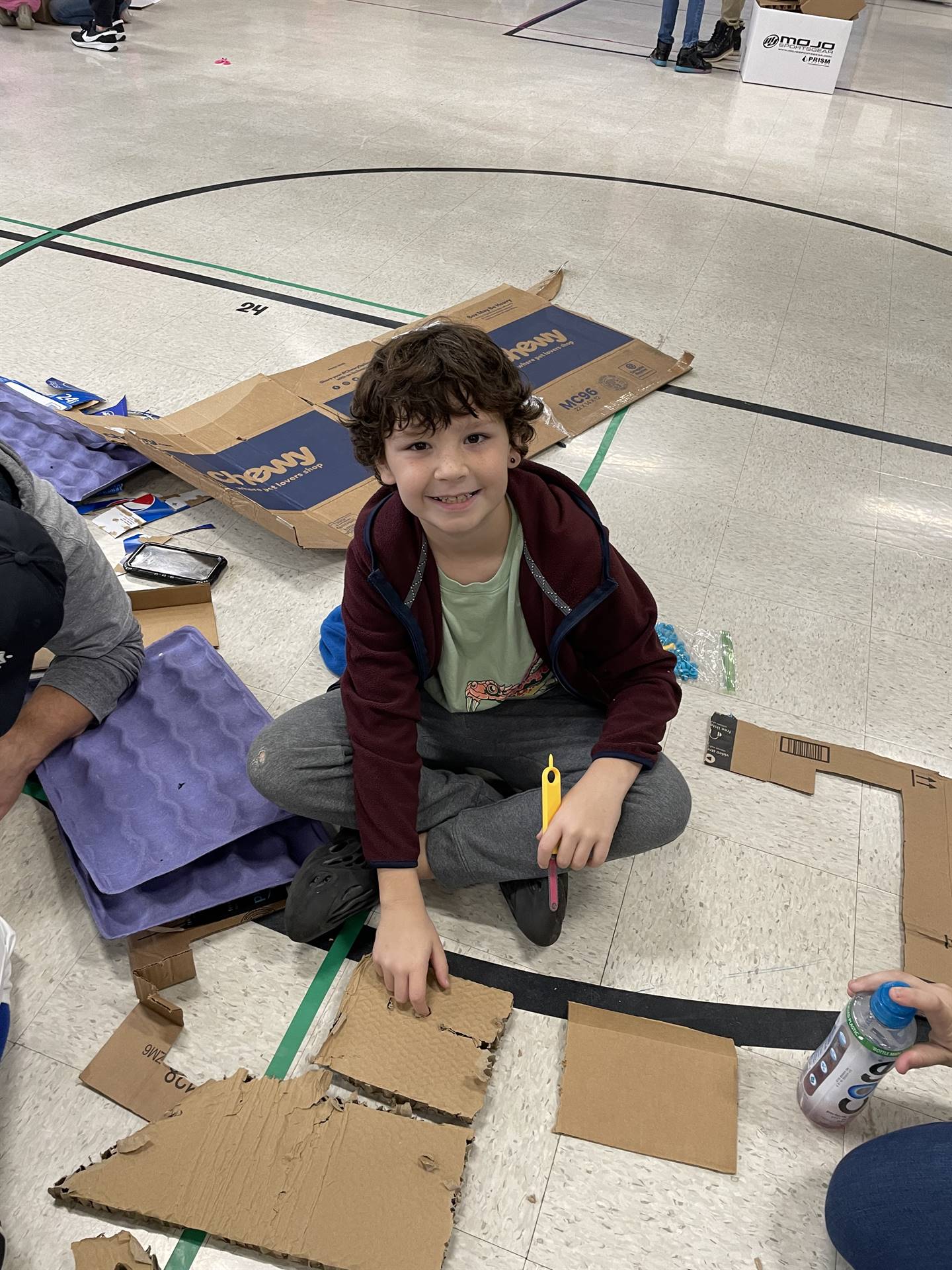 Firebird families in the gymnasium build with cardboard. 