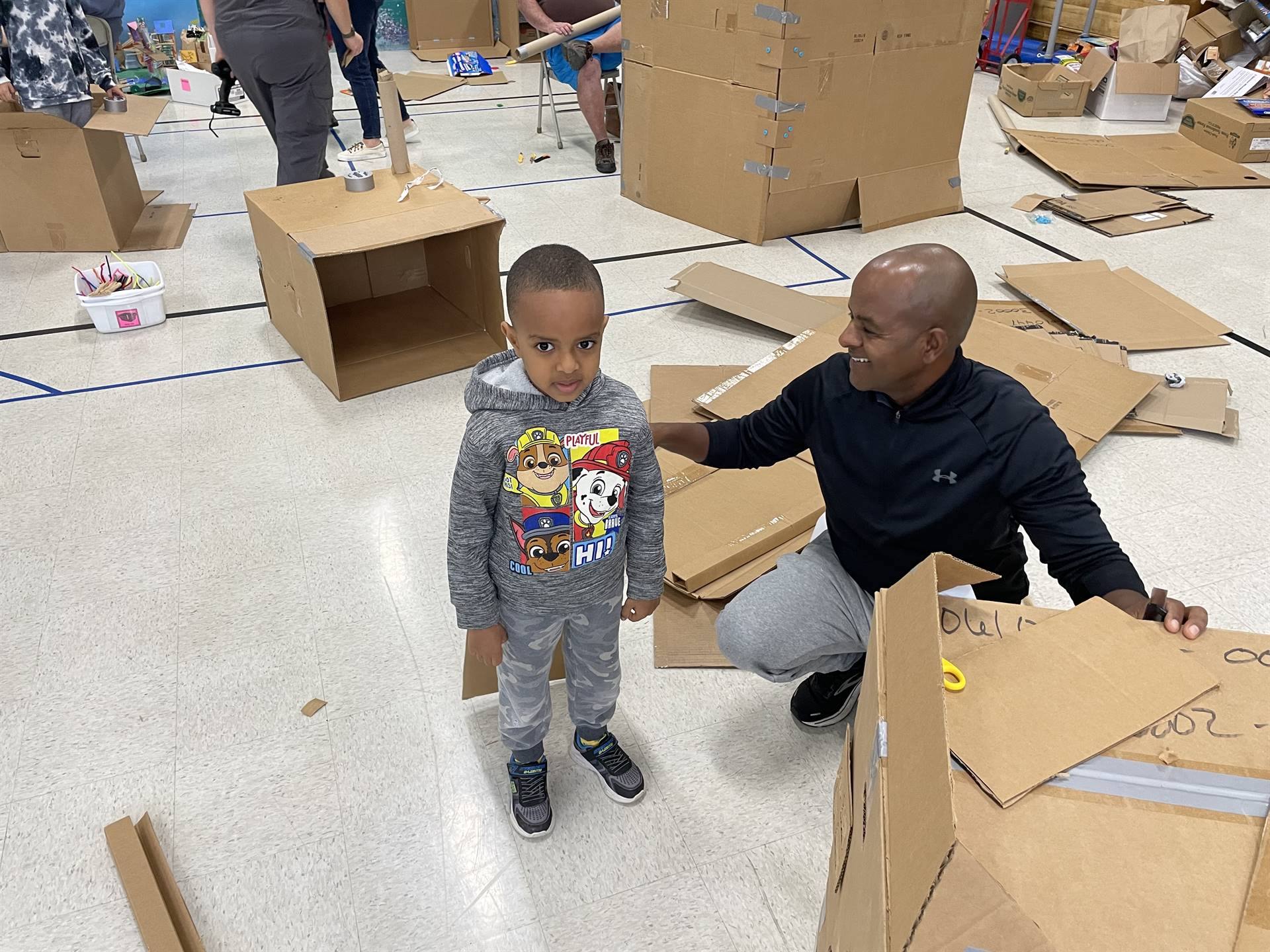 Firebird families in the gymnasium build with cardboard. 