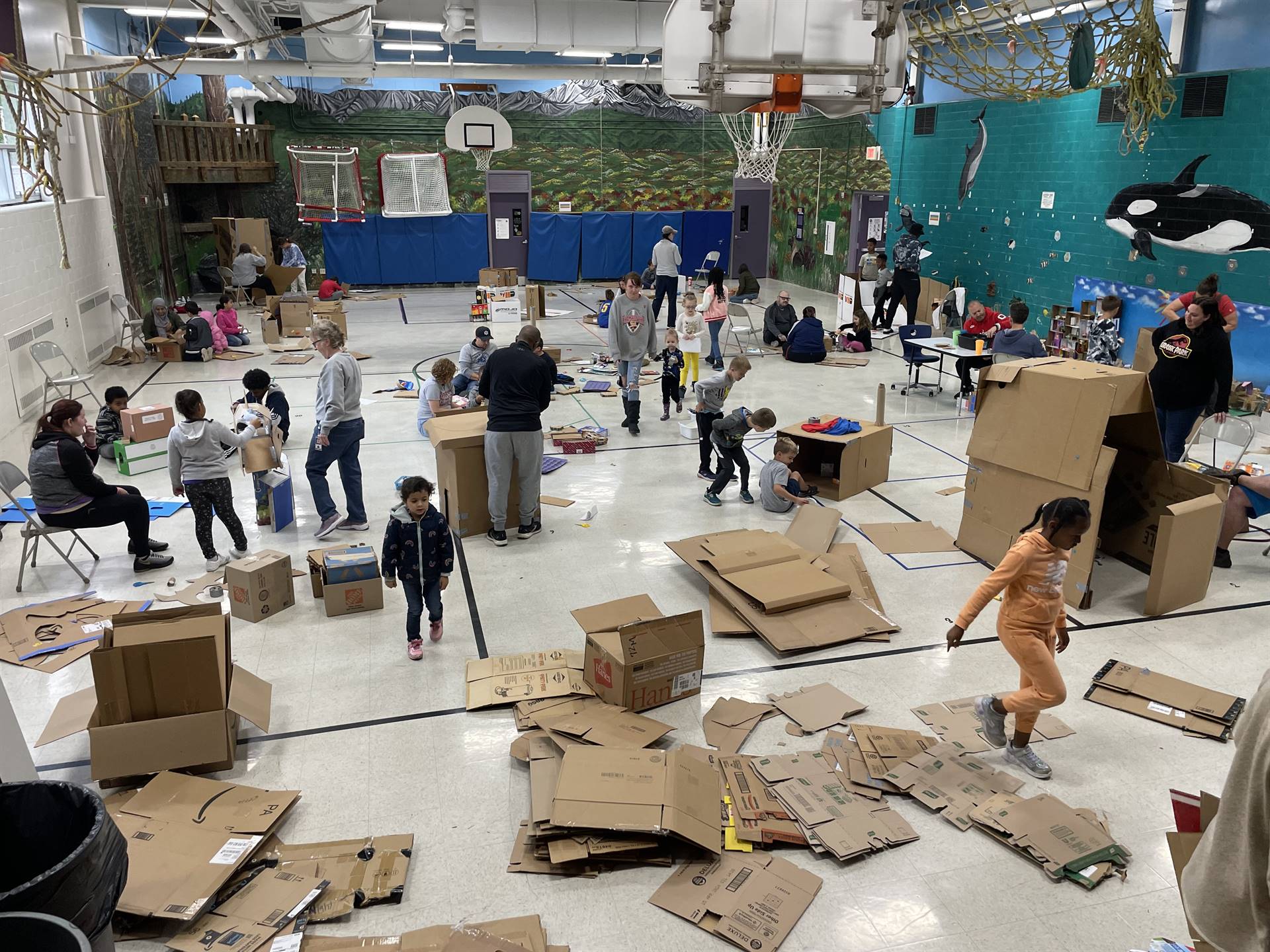 Firebird families in the gymnasium build with cardboard. 