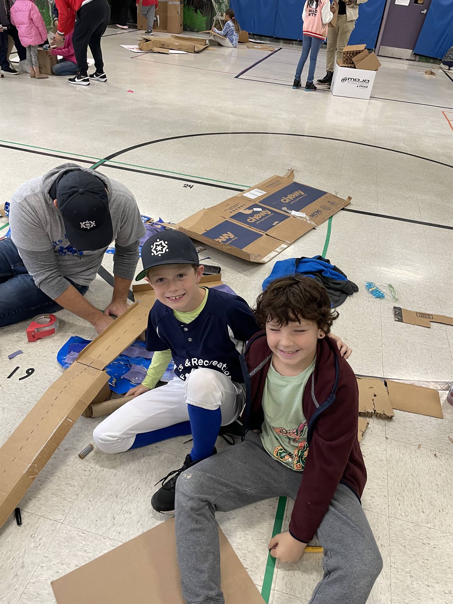 Firebird families in the gymnasium build with cardboard. 