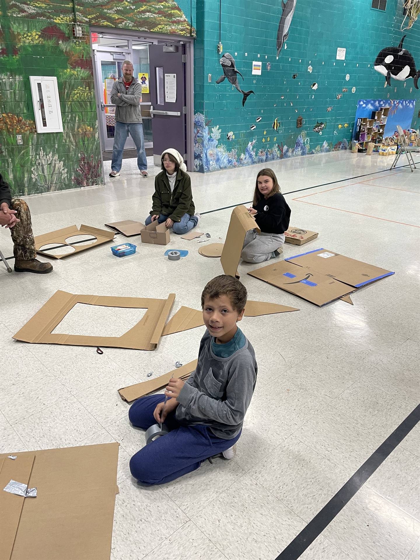 Firebird families in the gymnasium build with cardboard. 