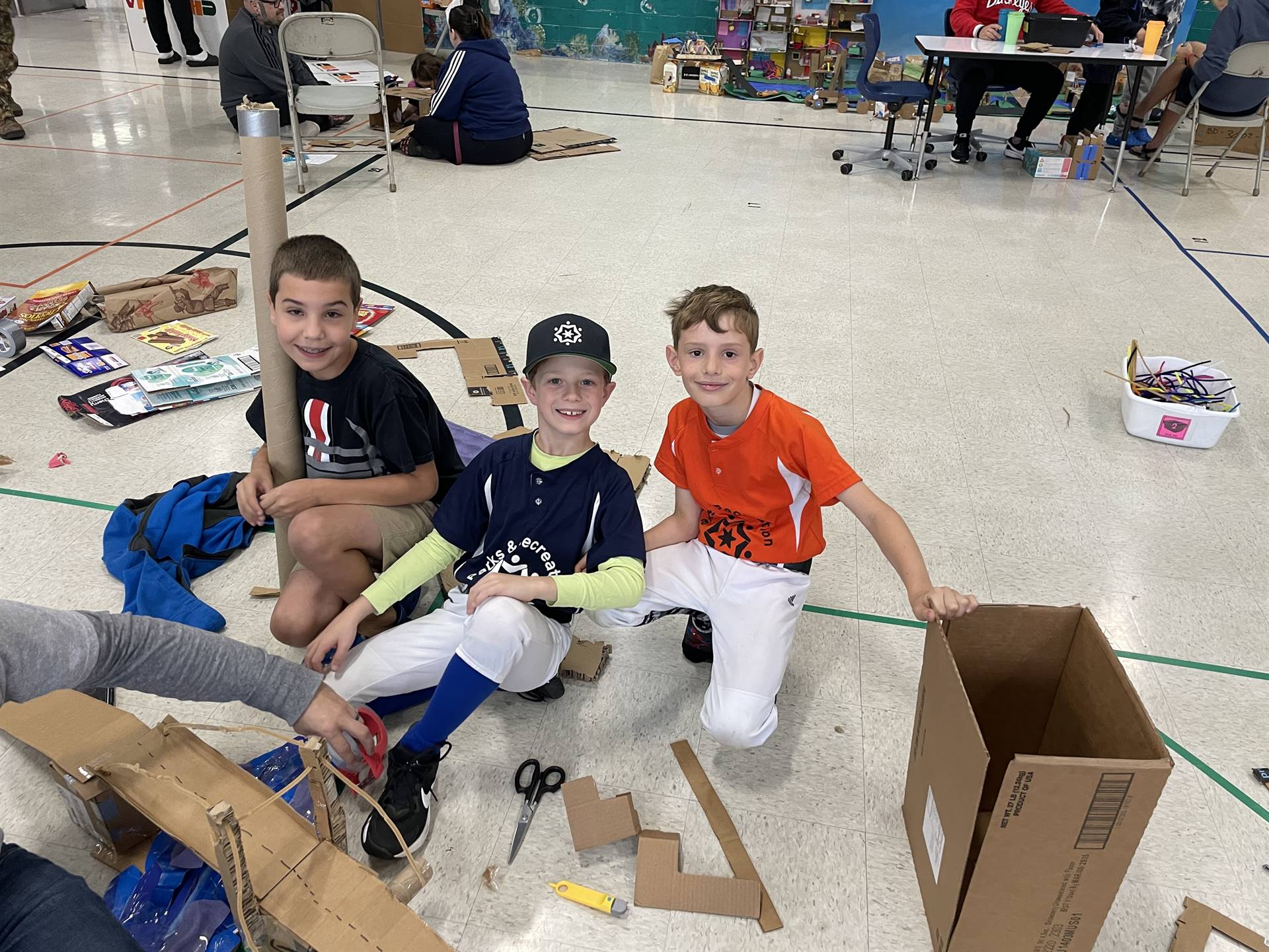 Firebird families in the gymnasium build with cardboard. 