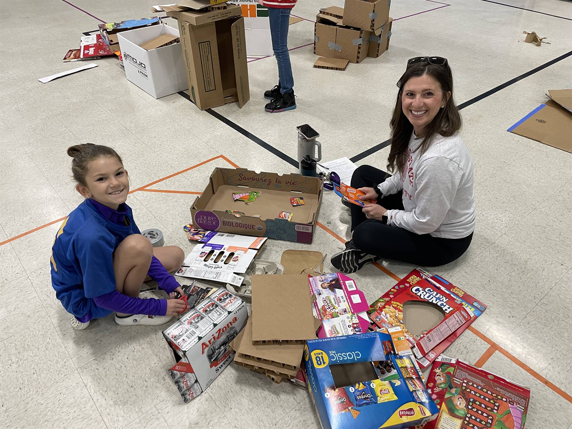 Firebird families in the gymnasium build with cardboard. 