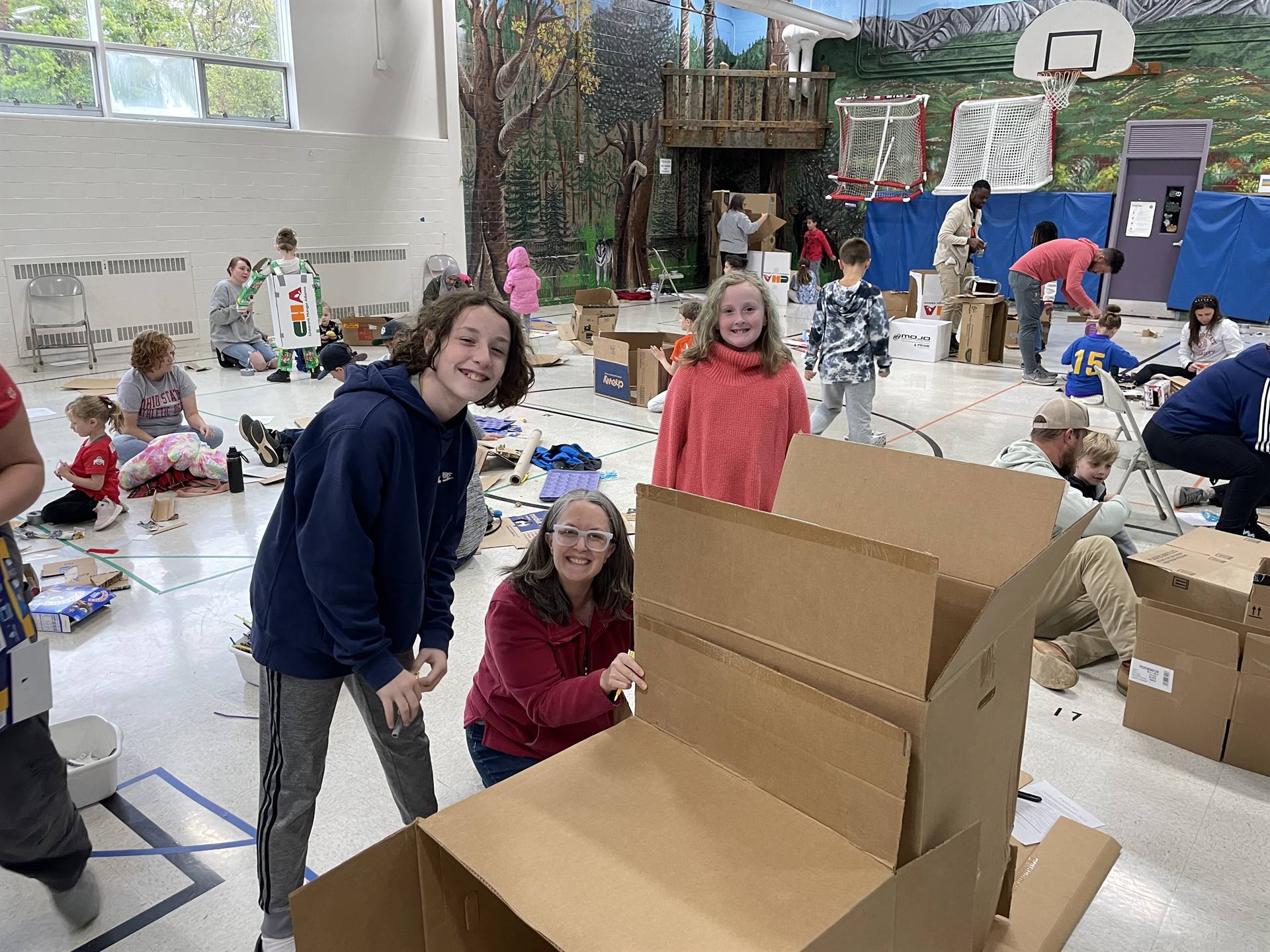 Firebird families in the gymnasium build with cardboard. 