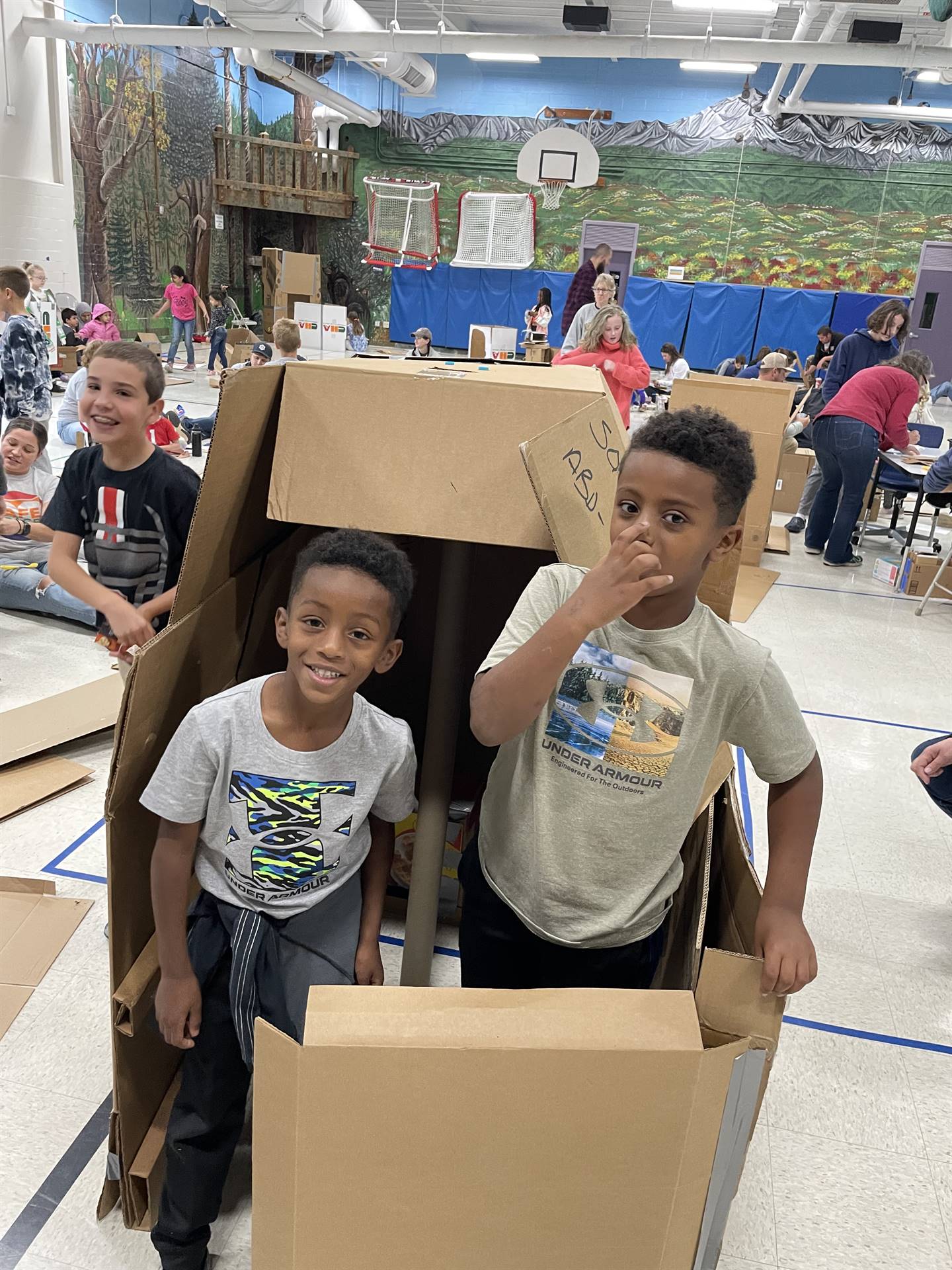 Firebird families in the gymnasium build with cardboard. 