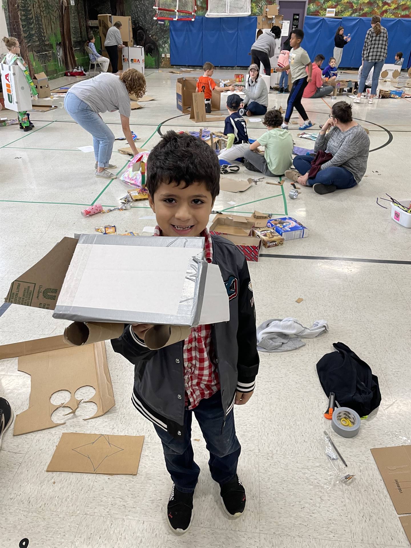 Firebird families in the gymnasium build with cardboard. 