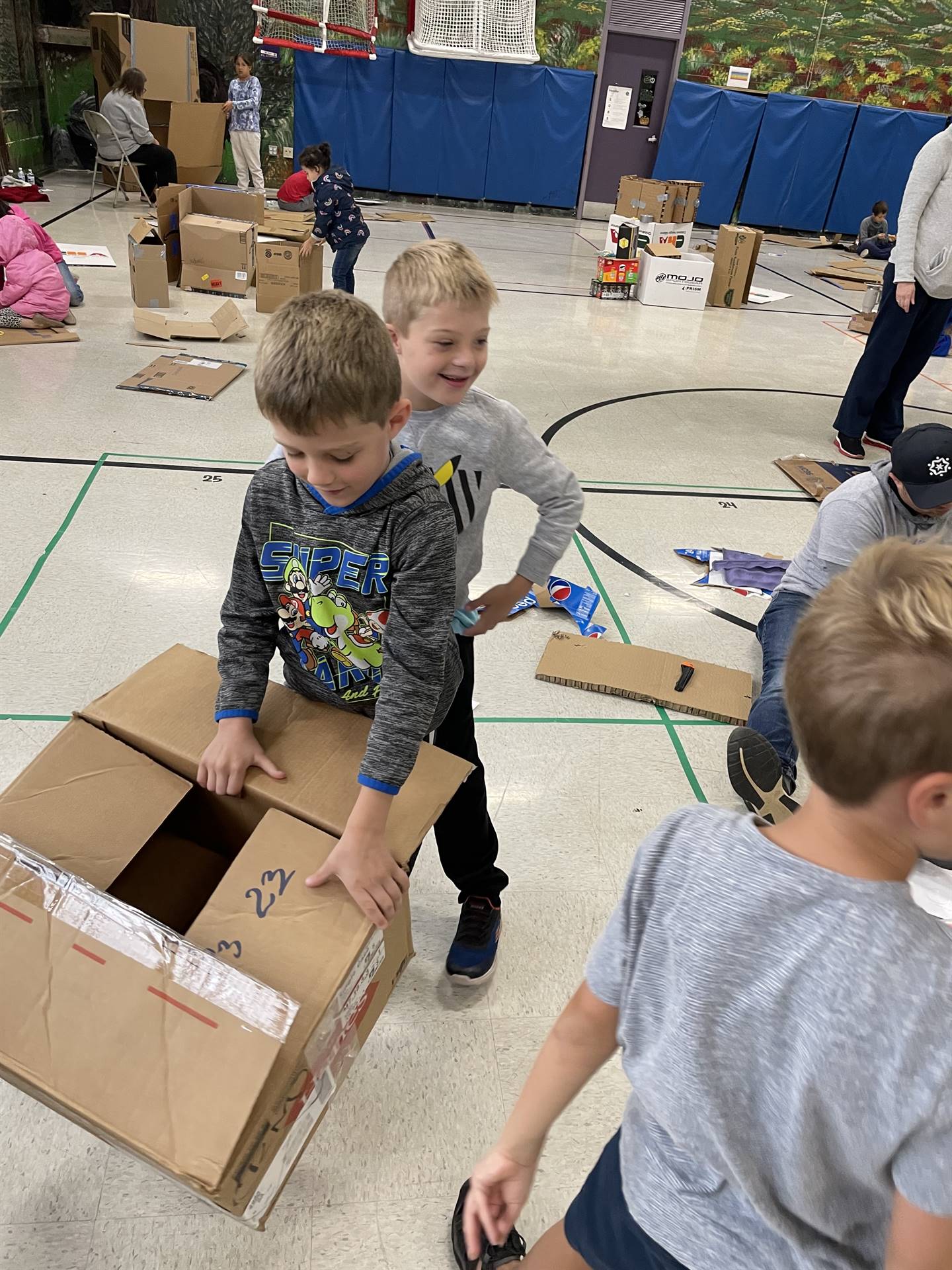 Firebird families in the gymnasium build with cardboard. 