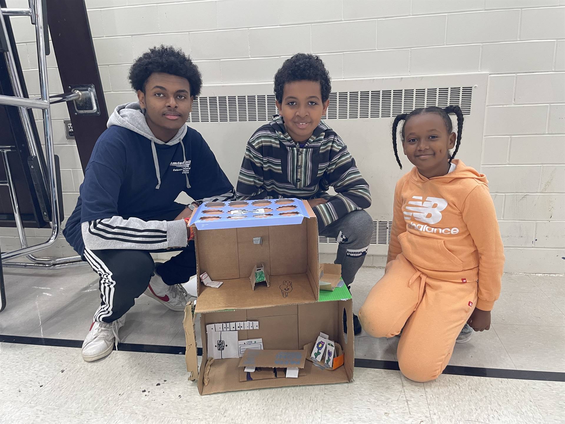 Firebird families in the gymnasium build with cardboard. 