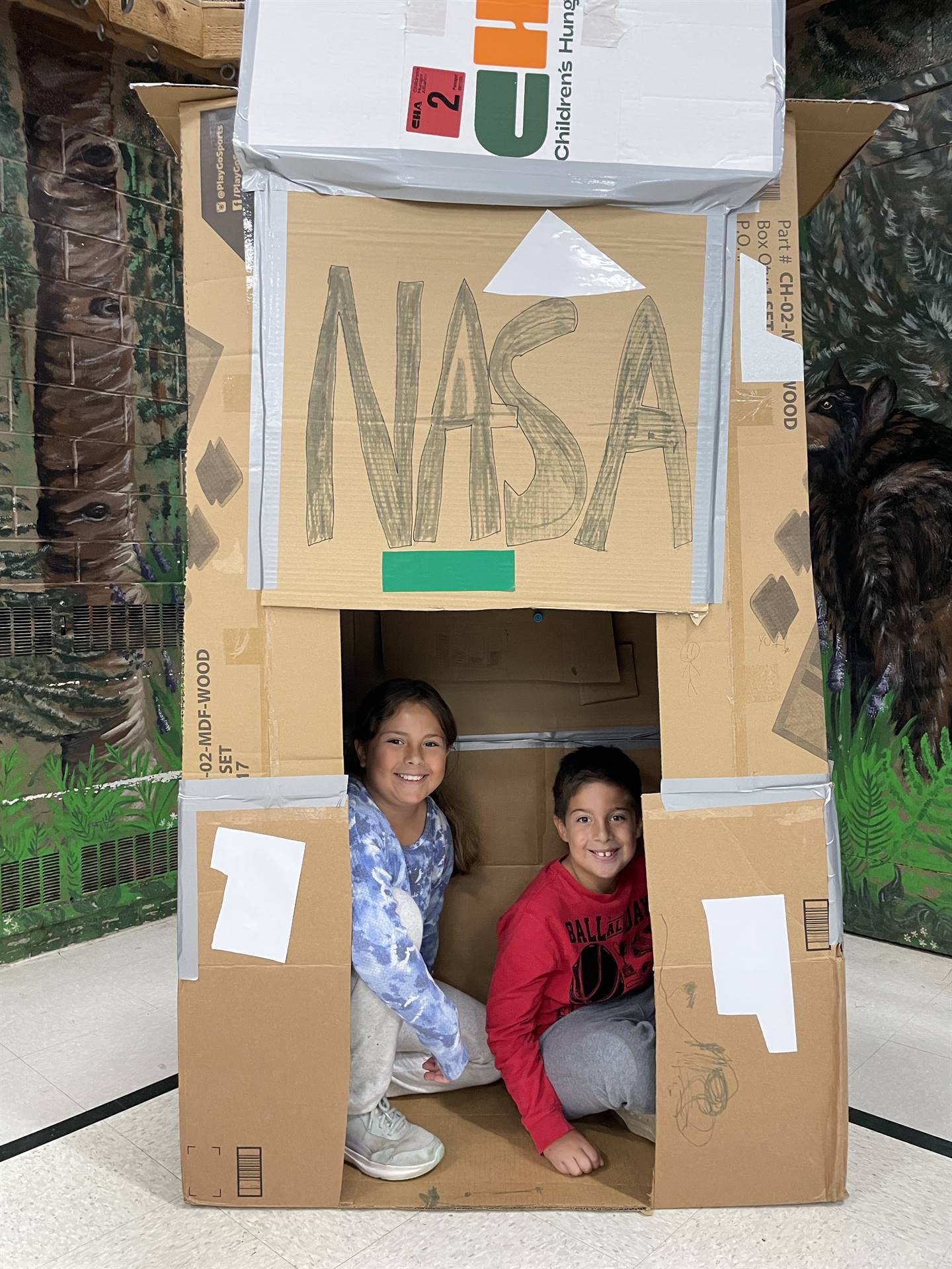 Firebird families in the gymnasium build with cardboard. 