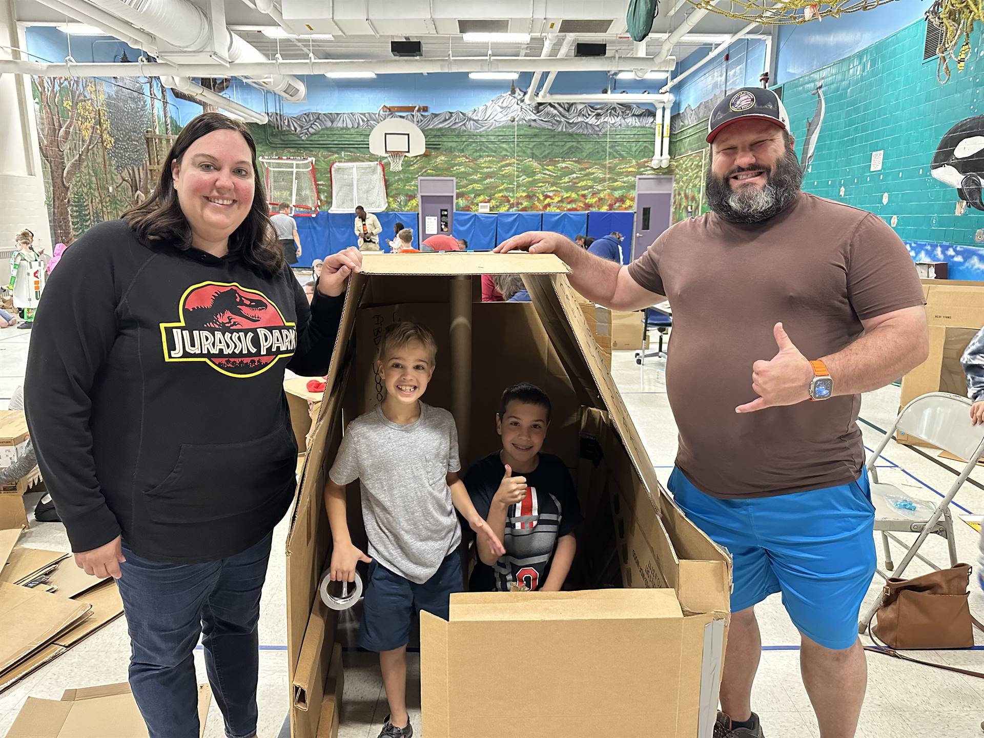 Firebird families in the gymnasium build with cardboard. 