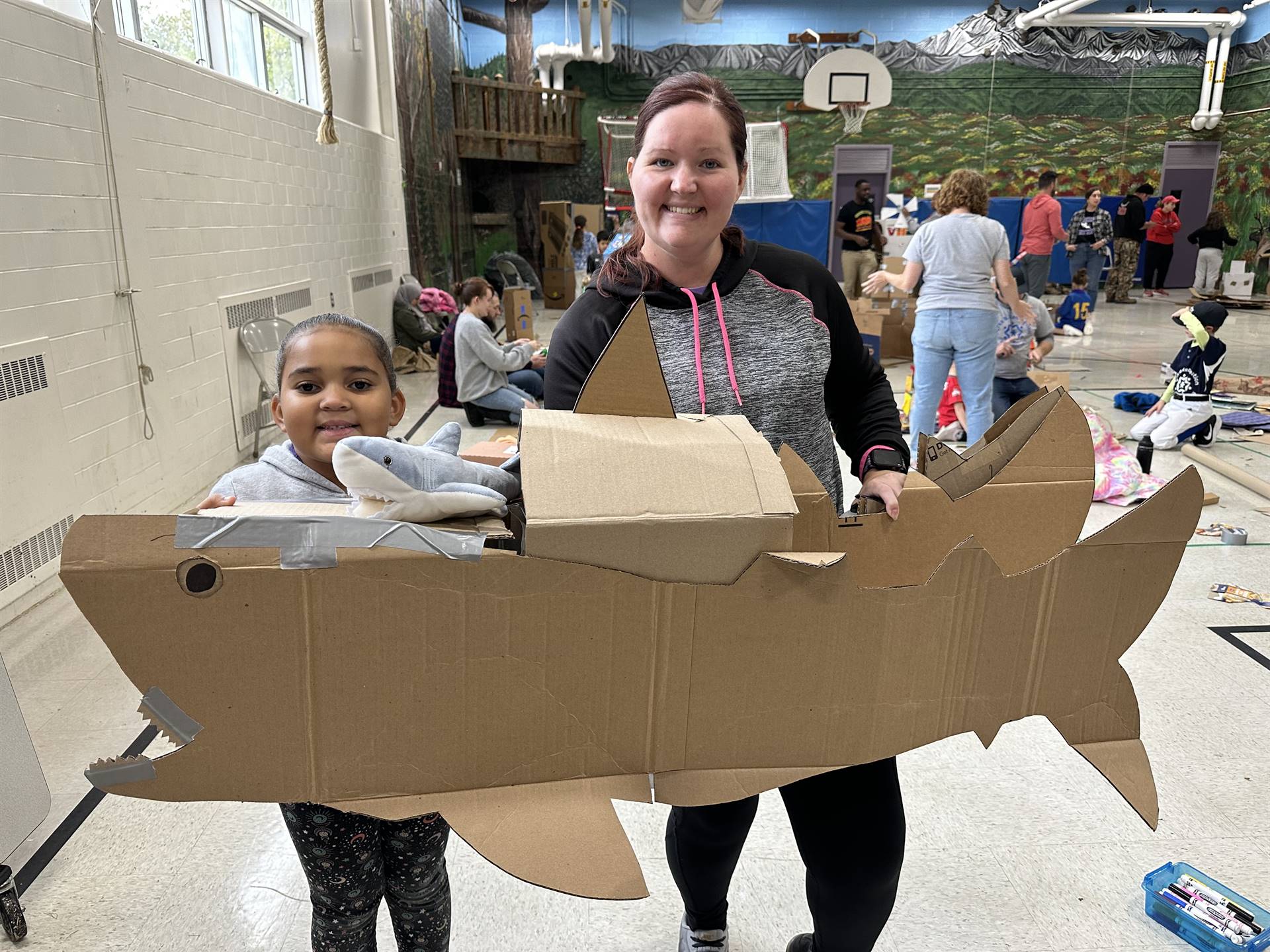 Firebird families in the gymnasium build with cardboard. 