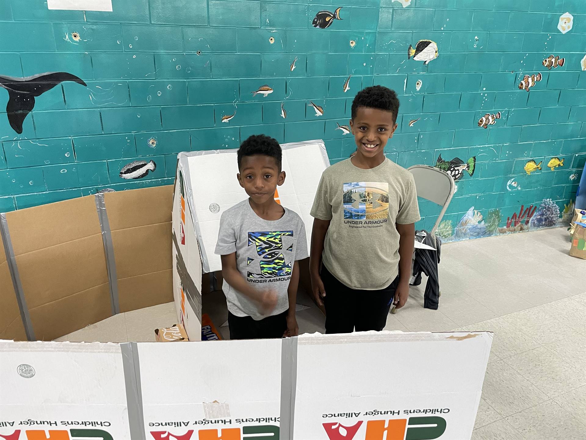 Firebird families in the gymnasium build with cardboard. 