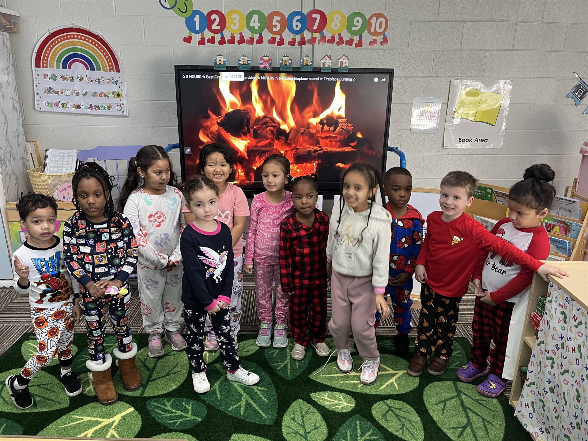 Preschoolers in pajamas in front of the fireplace