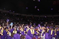 Graduates throw their caps up in the air