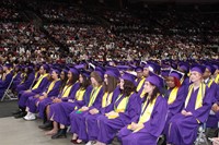 Graduates sit while listening to speakers