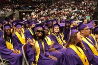 Graduates sit while listening to speakers