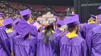 Students stand at the beginning of the graduation ceremony