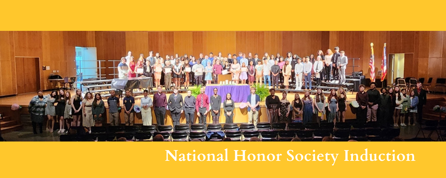 About 90 students stand in front of audience during National Honor Society induction ceremony