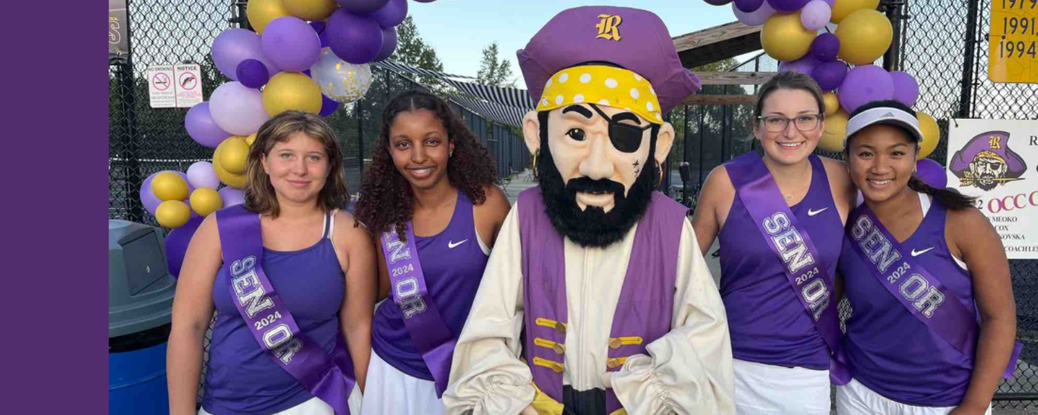 Seniors of the girls tennis team pose with Rocky the Raider in front of tennis courts