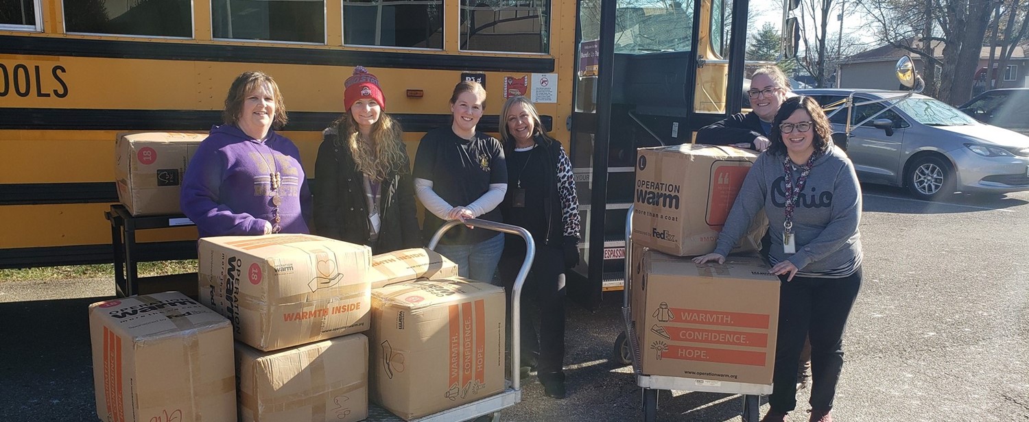 Volunteers loading boxes of coats into the Bundle Up Bus for the community