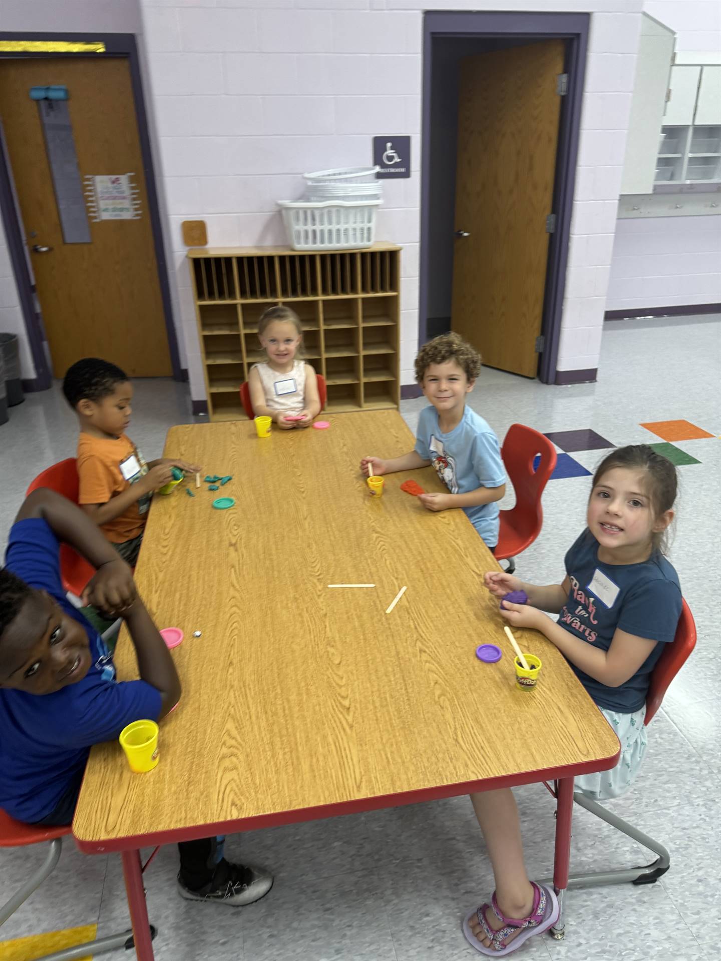 A table of kindergartners complete an activity.