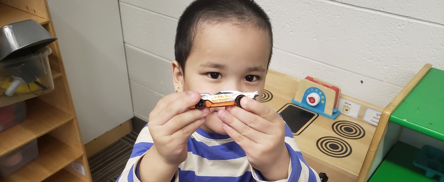 Preschooler playing with a toy car