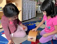 Two girls playing with toy cars