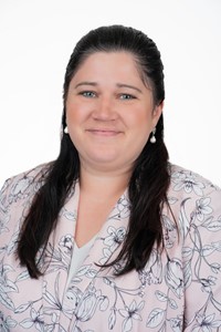 April Oates wearing a white floral blouse