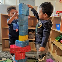 Two children building blocks together